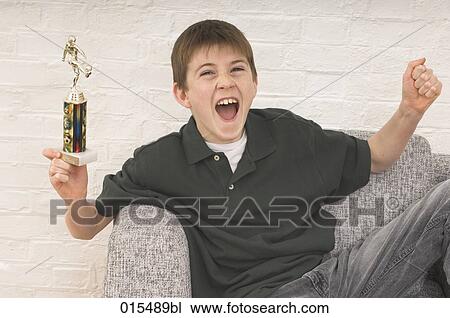 portrait of young boy celebrating with football trophy View Large Photo Image Stock Image - portrait of young boy celebrating with football trophy. Fotosearch