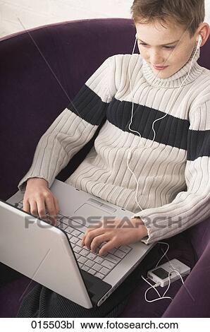 portrait of young boy listening to music on ipod and typing on laptop computer View Large Photo Image Stock Image - portrait of young boy listening to music on ipod and typing on laptop computer. Fotosearch