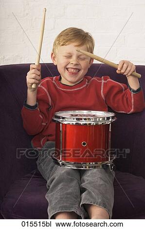 Stock Image - portrait of young boy playing on drum. Fotosearch