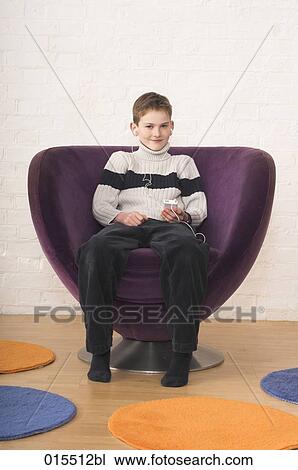 portrait of young boy sitting in arm chair listening to music on ipod View Large Photo Image Stock Image - portrait of young boy sitting in arm chair listening to music on ipod. Fotosearch