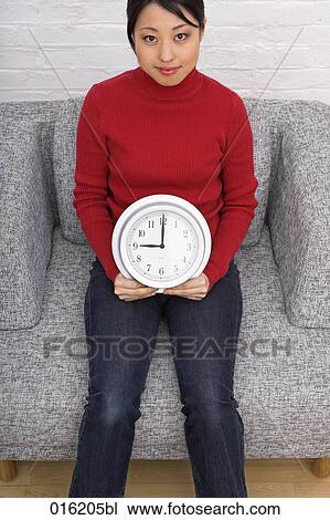 portrait of young japanese woman stitting in arm chair holding clock View Large Photo Image Stock Image - portrait of young japanese woman stitting in arm chair holding clock. Fotosearch