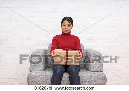 portrait of young japanese woman sitting in arm chair holding present View Large Photo Image Stock Image - portrait of young japanese woman sitting in arm chair holding present. Fotosearch