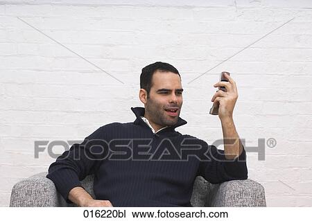 portrait of young man angrily looking at his mobile phone View Large Photo Image Stock Image - portrait of young man angrily looking at his mobile phone. Fotosearch