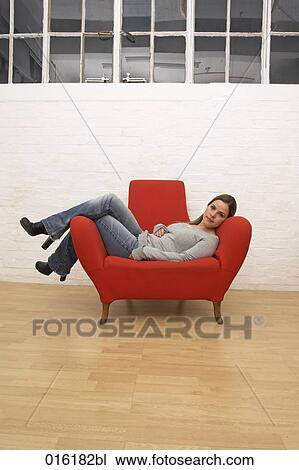 portrait of young woman sitting comfortably in red arm chair View Large Photo Image Stock Image - portrait of young woman sitting comfortably in red arm chair. Fotosearch
