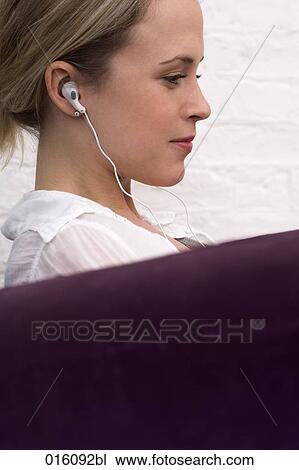 profile of young woman sitting on arm chair listening to music View Large Photo Image Stock Image - profile of young woman sitting on arm chair listening to music. Fotosearch