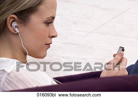 profile of young woman sitting on arm chair listening to music View Large Photo Image Stock Image - profile of young woman sitting on arm chair listening to music. Fotosearch