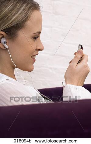 profile of young woman sitting on arm chair listening to music View Large Photo Image Stock Image - profile of young woman sitting on arm chair listening to music. Fotosearch