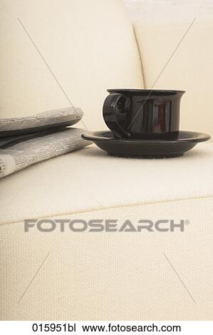 still life of newspaper and black coffee cup on white arm chair View Large Photo Image Stock Image - still life of newspaper and black coffee cup on white arm chair. Fotosearch
