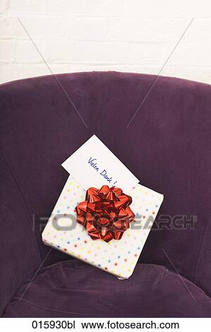 Stock Image - still life of of present with german note vielen dank on arm chair. Fotosearch