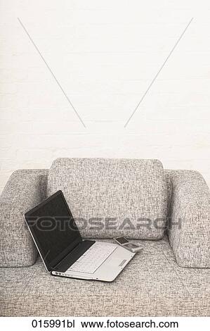 still life of open laptop computer and mobile phone on grey arm chair View Large Photo Image Stock Image - still life of open laptop computer and mobile phone on grey arm chair. Fotosearch