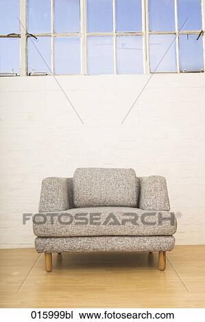 Stock Image - still life of single grey arm chair. Fotosearch