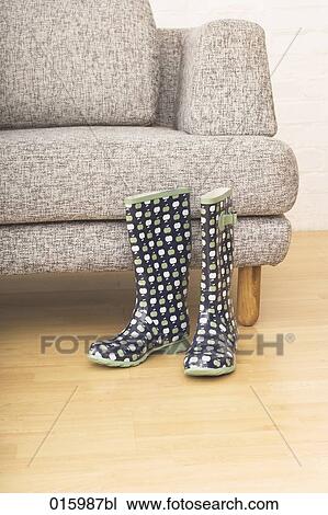 still life with pair of rubber boots in front of grey arm chair View Large Photo Image Stock Image - still life with pair of rubber boots in front of grey arm chair. Fotosearch