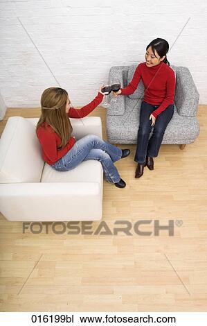 two young woman sitting in arm chairs dring red wine together View Large Photo Image Stock Image - two young woman sitting in arm chairs dring red wine together. Fotosearch