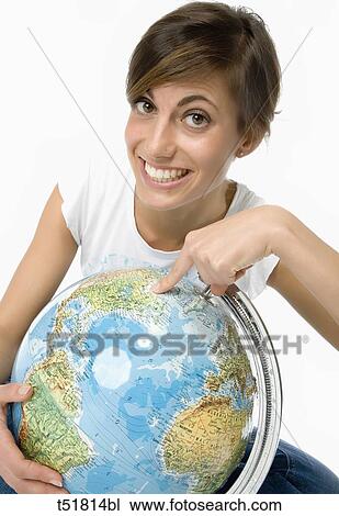Stock Image - Woman looking in a globe . Fotosearch