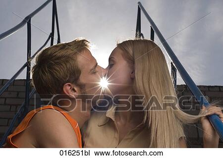 young couple kissing at sunset View Large Photo Image Stock Image - young couple kissing at sunset. Fotosearch
