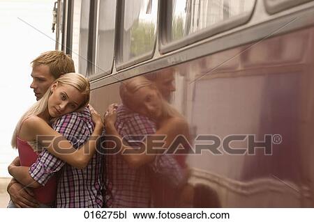 young couple standing at bus embracing woman looking sad View Large Photo Image Stock Image - young couple standing at bus embracing woman looking sad. Fotosearch