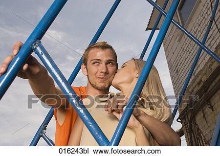 young couple standing on stairs woman kissing man on cheek View Large Photo Image Stock Image - young couple standing on stairs woman kissing man on cheek. Fotosearch