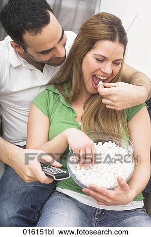 Stock Image - young couple watching tv together at home. Fotosearch
