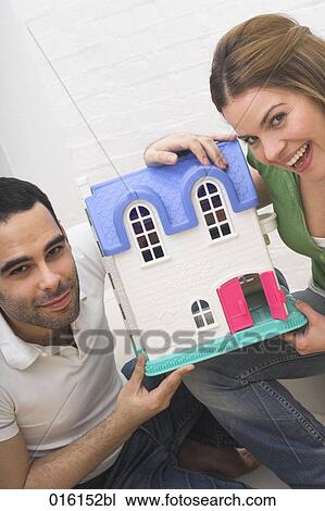 young couple with miniature house View Large Photo Image Stock Image - young couple with miniature house. Fotosearch