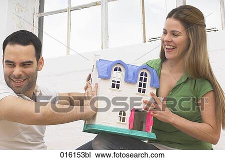 young couple with miniature house View Large Photo Image Stock Image - young couple with miniature house. Fotosearch