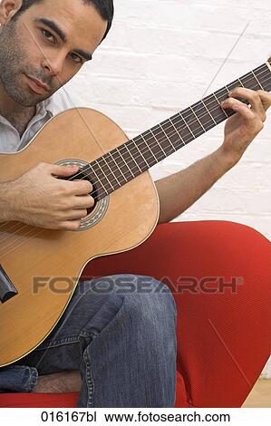 young man playing guitar at home View Large Photo Image Stock Image - young man playing guitar at home. Fotosearch