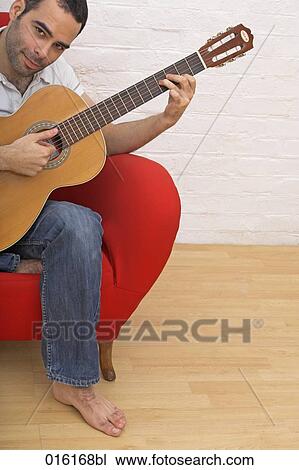 young man playing guitar at home View Large Photo Image Stock Image - young man playing guitar at home. Fotosearch