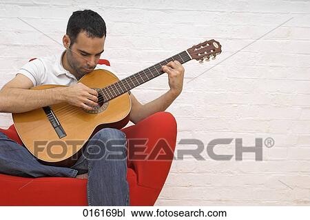 young man playing guitar at home View Large Photo Image Stock Image - young man playing guitar at home. Fotosearch