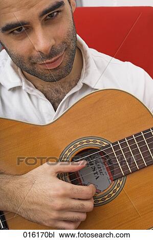 young man playing guitar at home View Large Photo Image Stock Image - young man playing guitar at home. Fotosearch