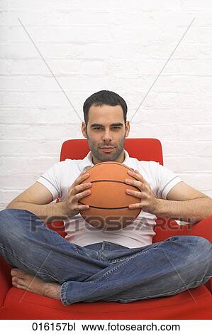 young man sitting on red arm chair holding basketball View Large Photo Image Stock Image - young man sitting on red arm chair holding basketball. Fotosearch