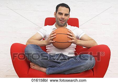 young man sitting on red arm chair holding basketball View Large Photo Image Stock Image - young man sitting on red arm chair holding basketball. Fotosearch