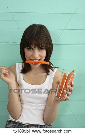 Young woman eats carrot View Large Photo Image Stock Image - Young woman eats carrot . Fotosearch