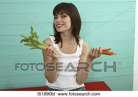 Young woman eats vegetables View Large Photo Image Stock Image - Young woman eats vegetables . Fotosearch
