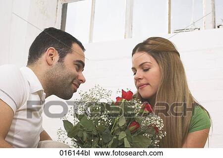 young woman giving young woman bouquet of red roses View Large Photo Image Stock Image - young woman giving young woman bouquet of red roses. Fotosearch