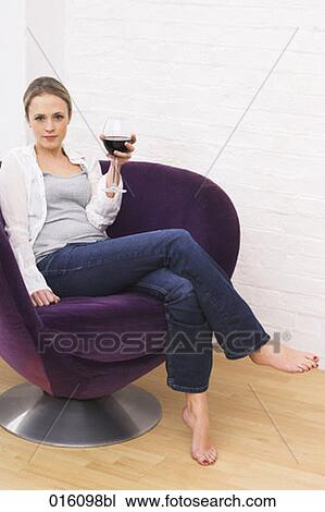 young woman sitting in purple arm chair holding glass of red wine View Large Photo Image Stock Image - young woman sitting in purple arm chair holding glass of red wine. Fotosearch