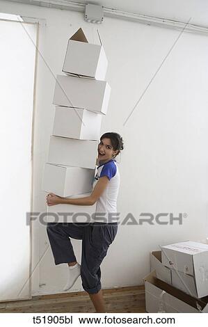 Young woman takes a stack of paper boxes View Large Photo Image Stock Image - Young woman takes a stack of paper boxes . Fotosearch