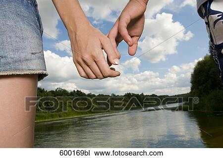 close-up of young couple holding hands View Large Photo Image Stock Image - close-up of young couple holding hands. Fotosearch