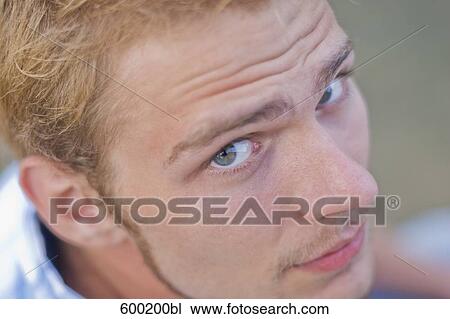 Stock Image - close-up of young man looking at camera. Fotosearch