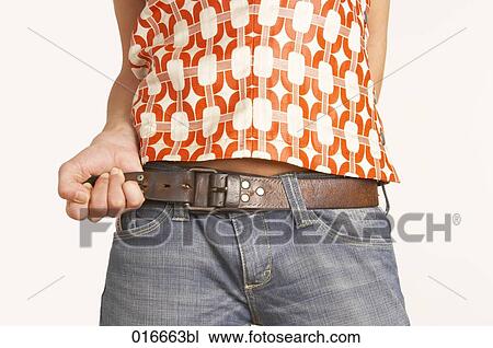 close-up of young woman pulling belt of her jeans View Large Photo Image Stock Image - close-up of young woman pulling belt of her jeans. Fotosearch