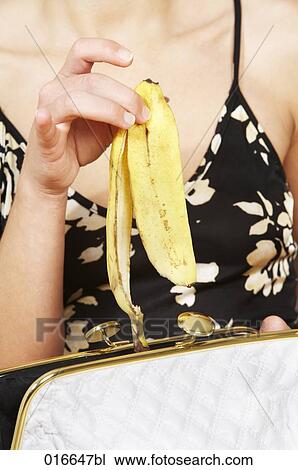 close-up of young woman putting banana peel into ther handbag View Large Photo Image Stock Image - close-up of young woman putting banana peel into ther handbag. Fotosearch