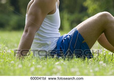 detail of young man sitting on lawn in park View Large Photo Image Stock Image - detail of young man sitting on lawn in park. Fotosearch