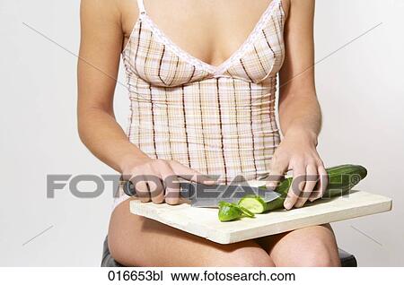 detail of young woman cutting cucumber on cutting board View Large Photo Image Stock Image - detail of young woman cutting cucumber on cutting board. Fotosearch