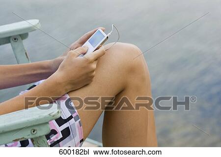 detail of young woman holding ipod View Large Photo Image Stock Image - detail of young woman holding ipod. Fotosearch