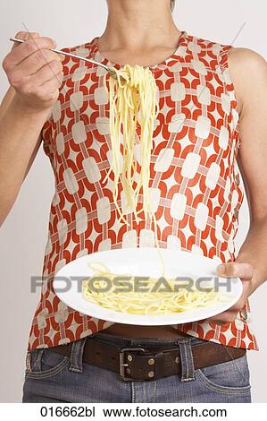 detail of young woman holding plate with spaghetti View Large Photo Image Stock Image - detail of young woman holding plate with spaghetti. Fotosearch