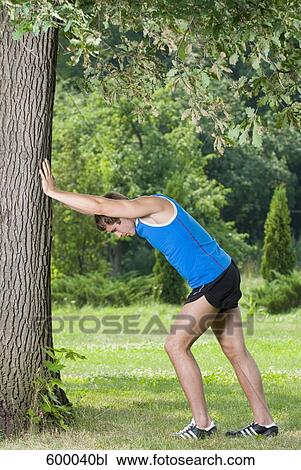 full body portait of young man doing stretching exercise in park View Large Photo Image Stock Image - full body portait of young man doing stretching exercise in park. Fotosearch
