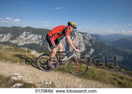Stock Image - full body portrait of young man on mountain bike. Fotosearch