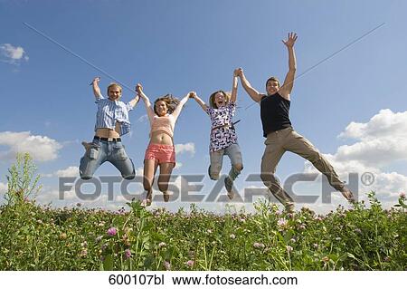 group of four friends jumping in summer meadow View Large Photo Image Stock Image - group of four friends jumping in summer meadow. Fotosearch