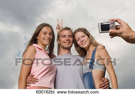 Stock Image - group of three friends posing for a portrait. Fotosearch