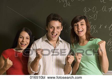 Stock Image - group of three students celebrating in front of blackboard. Fotosearch