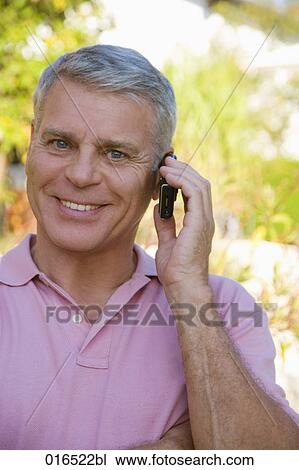 Stock Image - headshot of mature man talking on mobile phone. Fotosearch