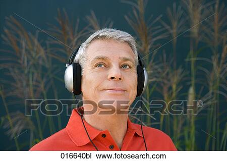headshot of mature man wearing red shirt listening to music on headphones View Large Photo Image Stock Image - headshot of mature man wearing red shirt listening to music on headphones. Fotosearch